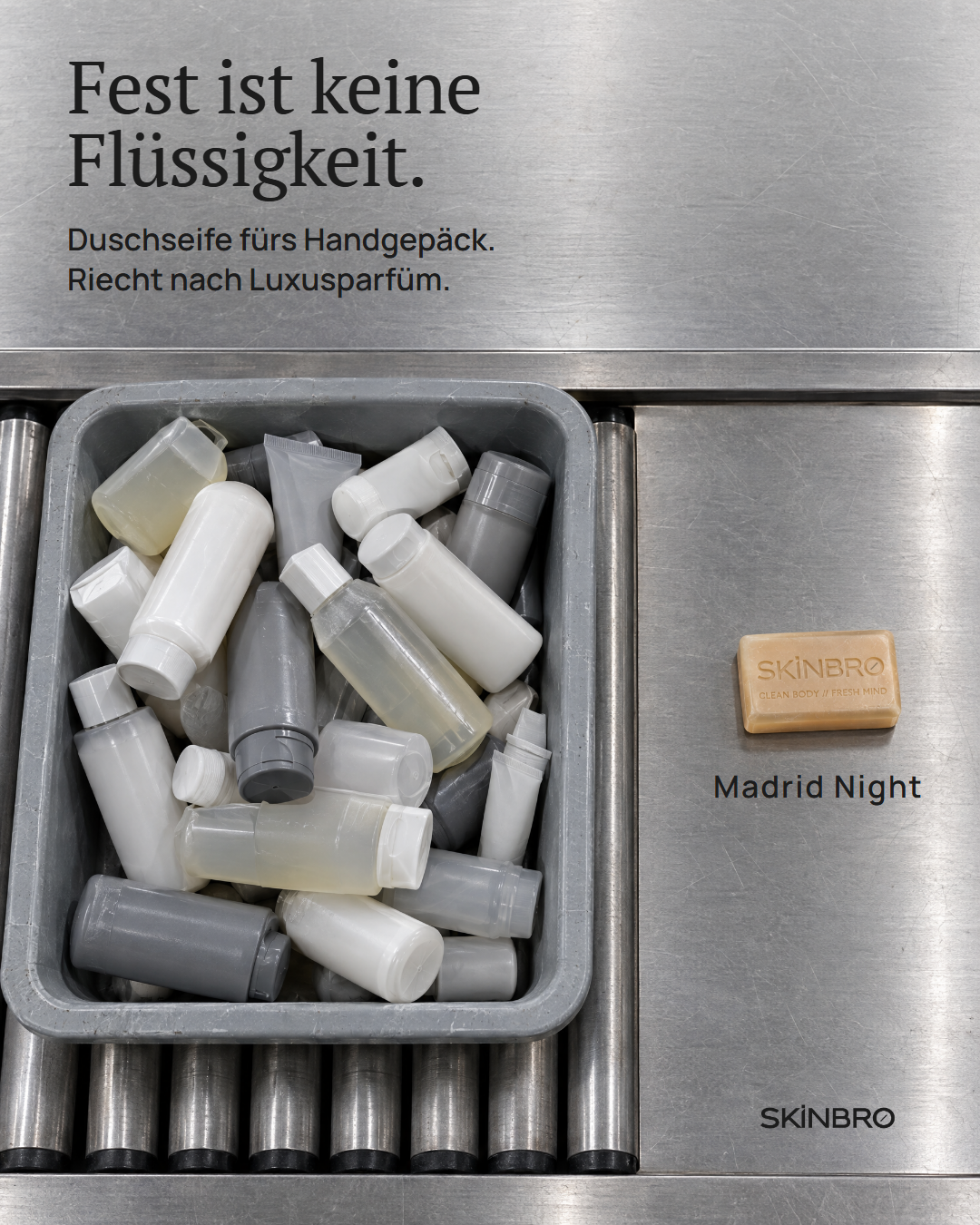 Eine Sicherheitsschale am Flughafen voller abgenommener Flüssigkeiten, daneben ein Riegel SKINBRO Duschseife Madrid Night